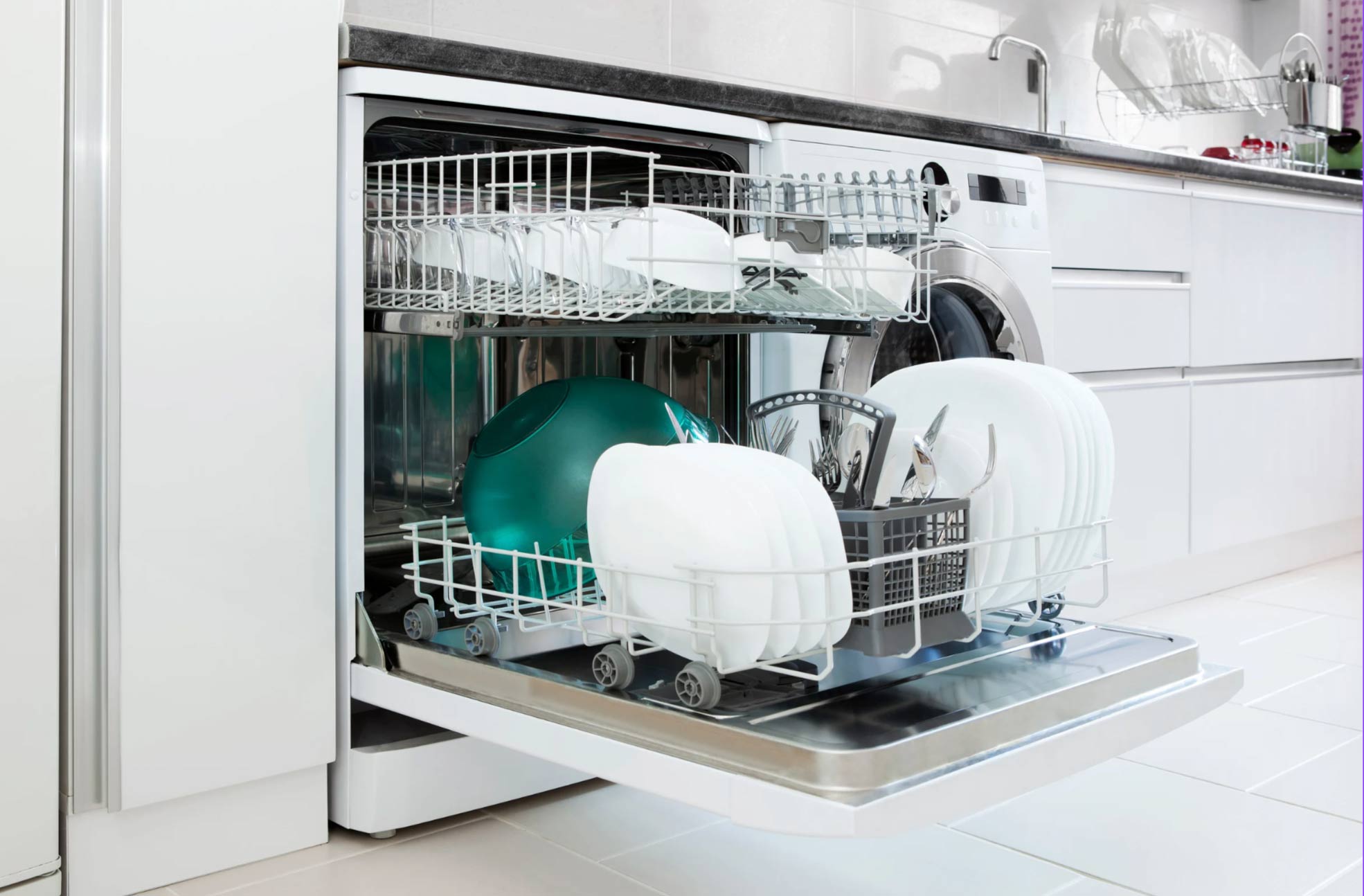 Open refrigerator filled with fresh vegetables and bottles of juice on the shelves in a modern kitchen.